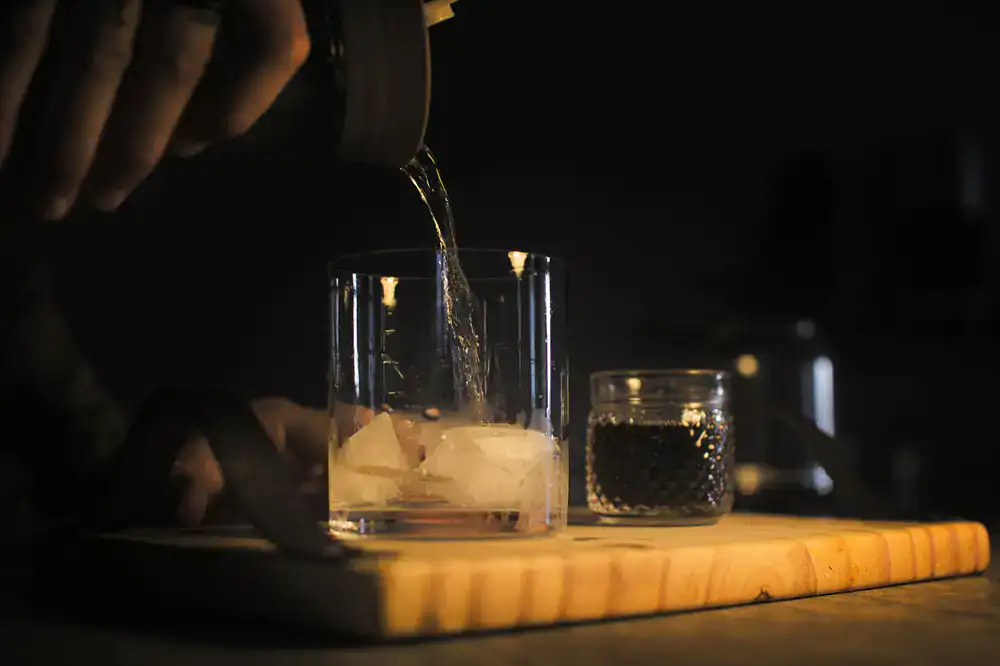 Pouring premium botanical gin into a crystal glass